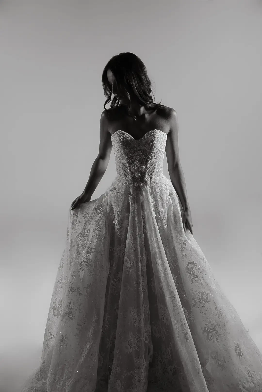 model is wearing a strapless lace wedding gown