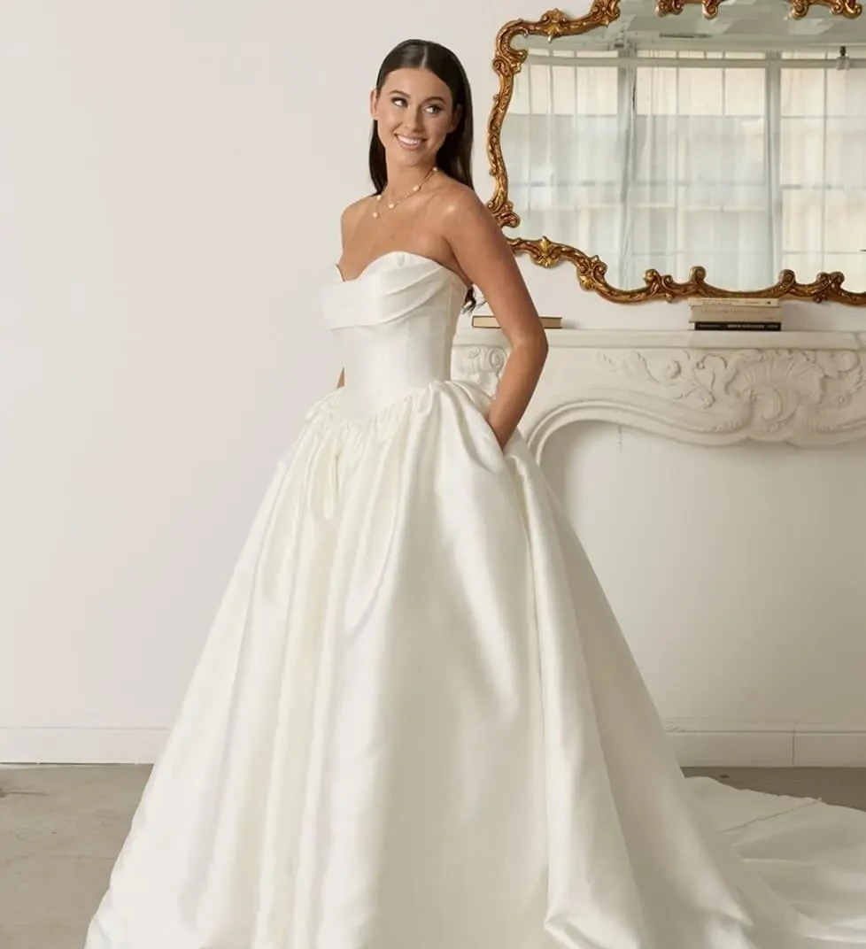 Model wearing a white bridal gown near the mirror