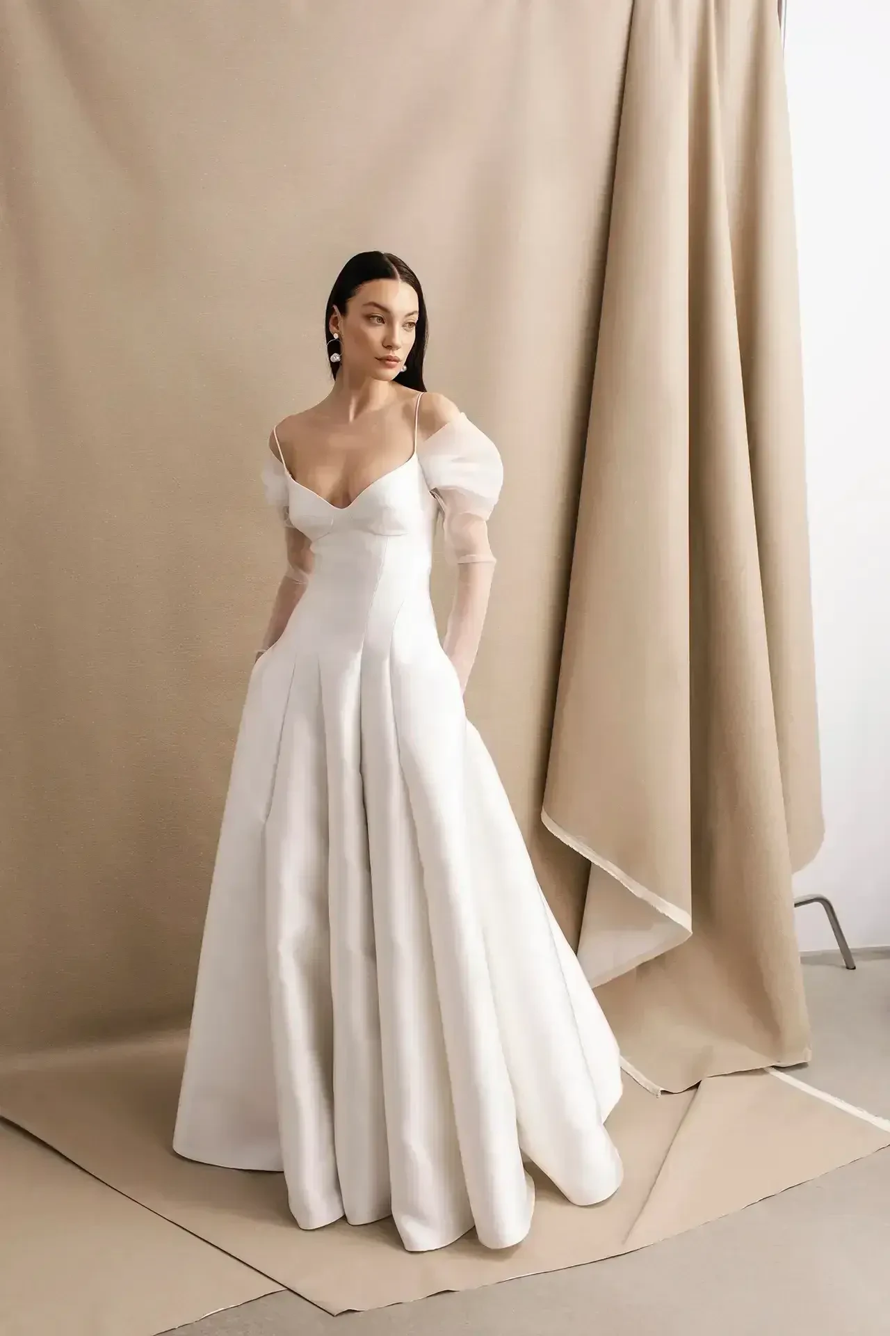 model is wearing an off the shoulder a-line wedding dress