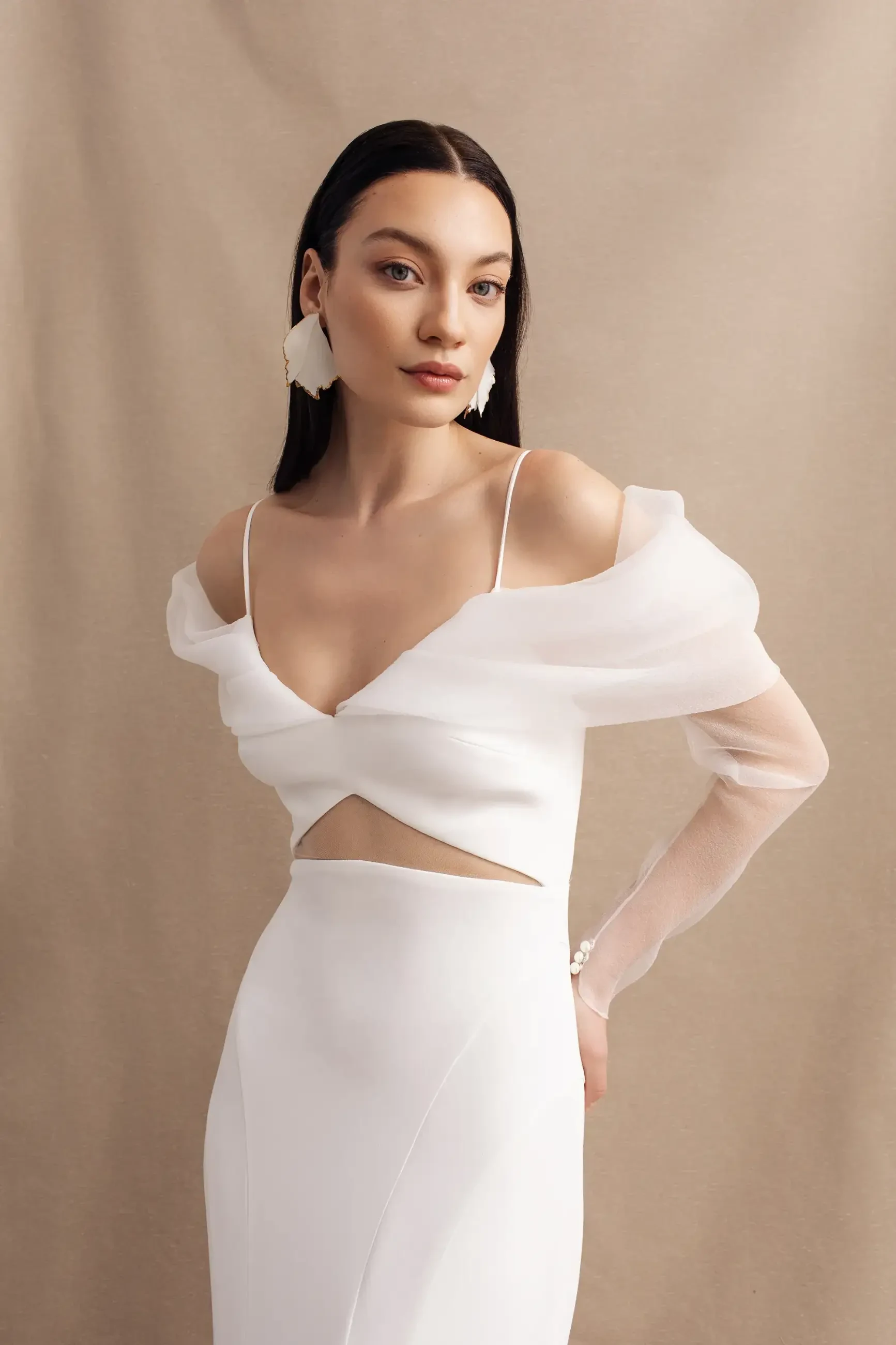 model is wearing an off the shoulder wedding dress with a keyhole cutout in the front