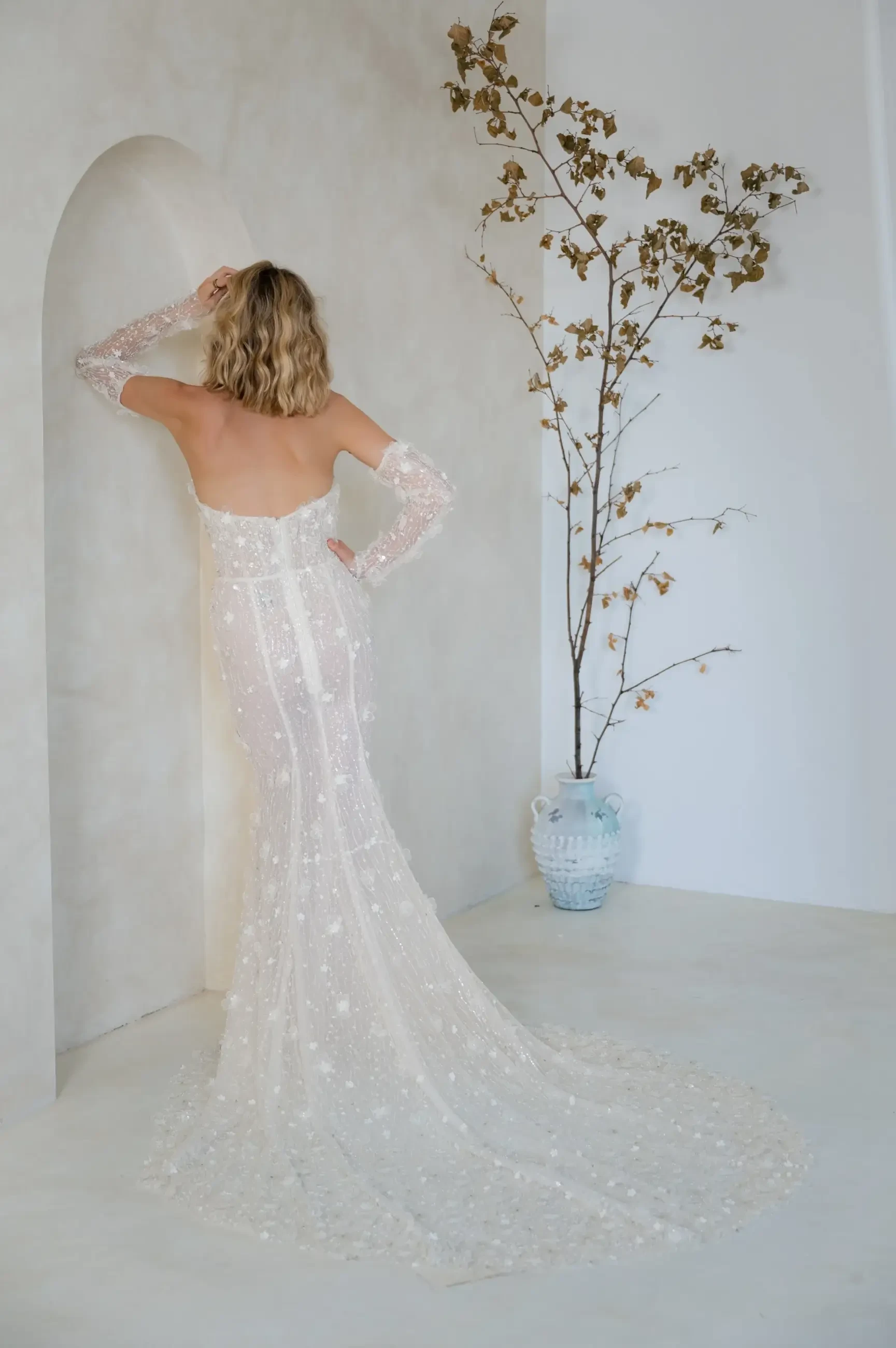 model is wearing a strapless fit and flare wedding dress with a plunging neckline and 3d floral appliques